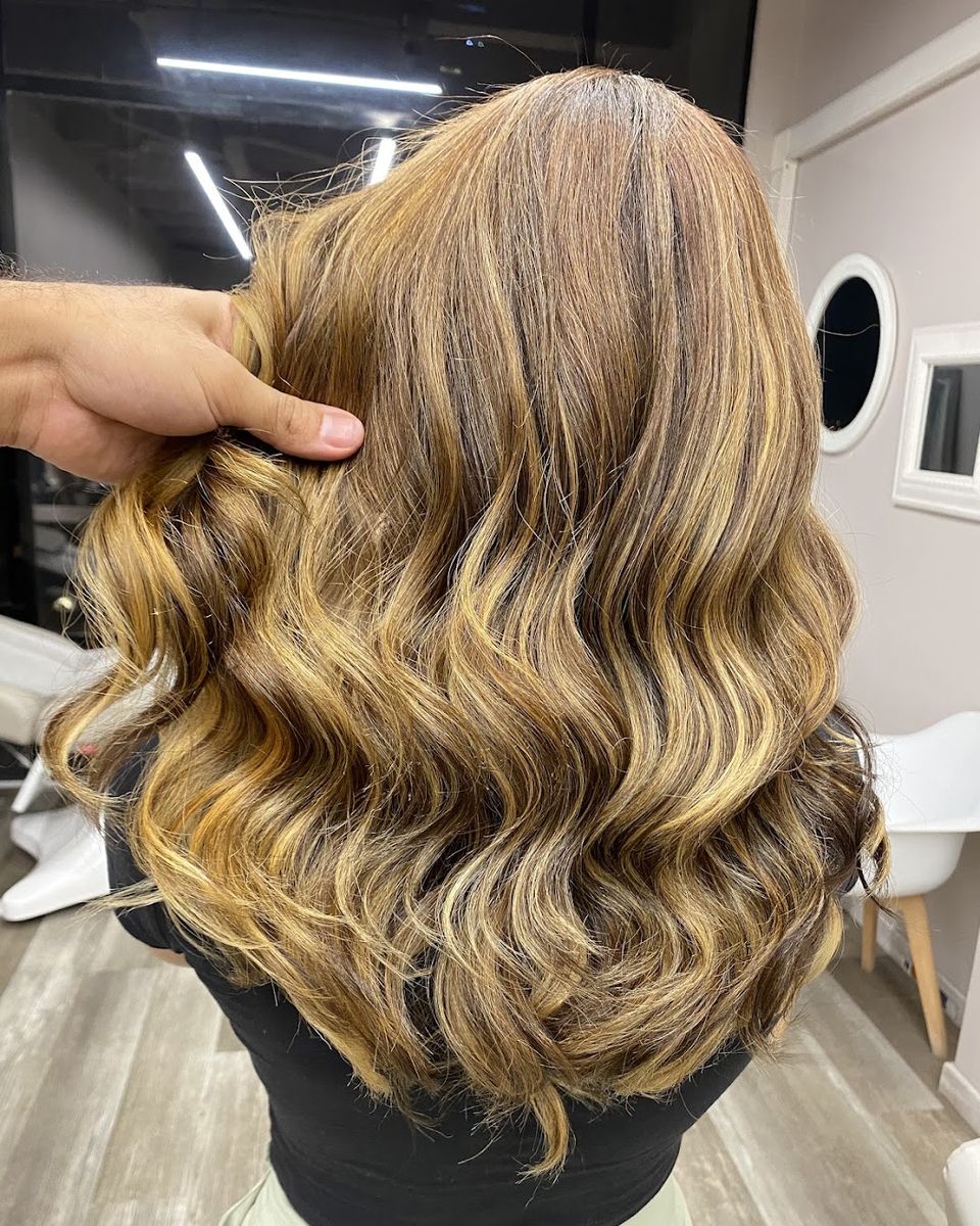 Balayage dorado con ondas, visto de espalda en el salón