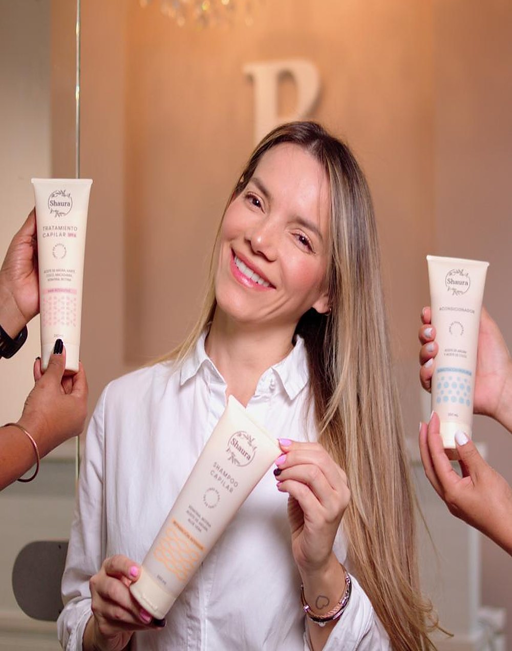 Shirley Rincón con el shampoo, el acondicionador y el tratamiento capilar Shaura